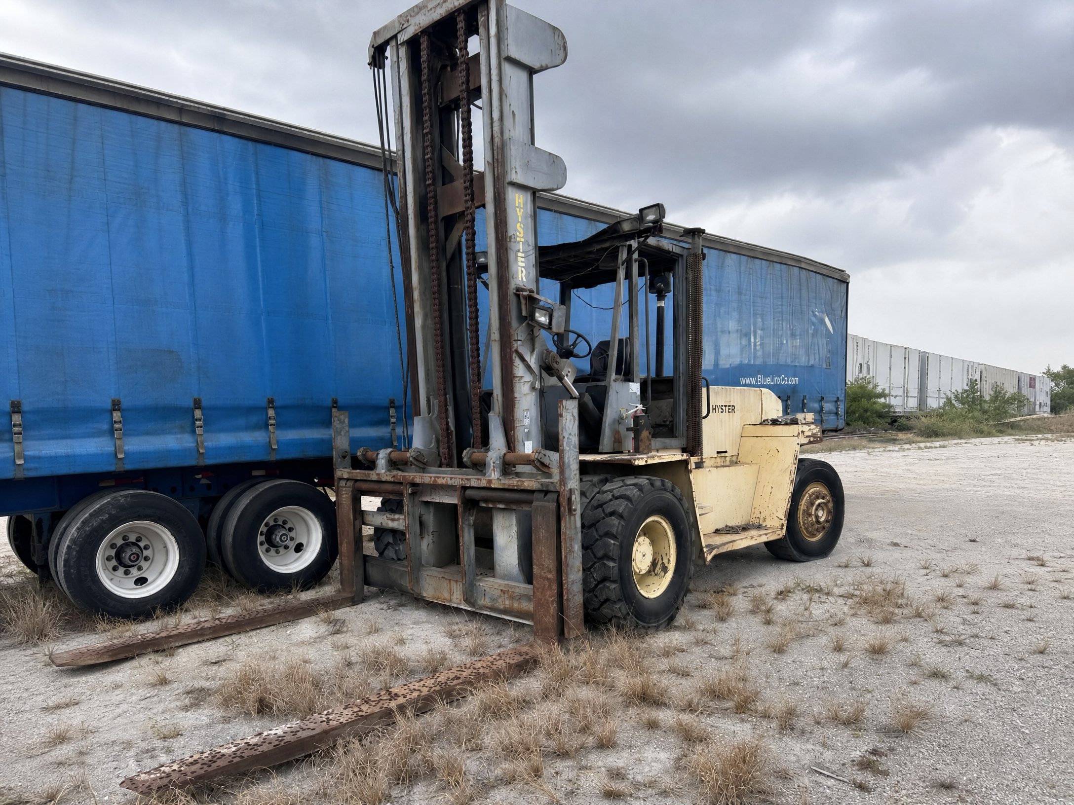 Older Hyster forklift beside a semi-trailer